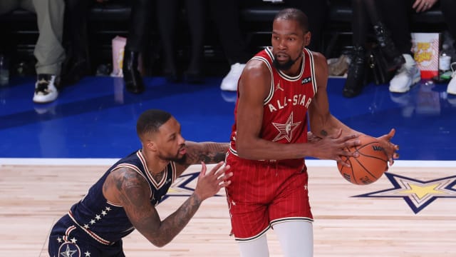 Western Conference forward Kevin Durant (35) of the Phoenix Suns looks to pass the ball against Eastern Conference guard Damian Lillard (0) 